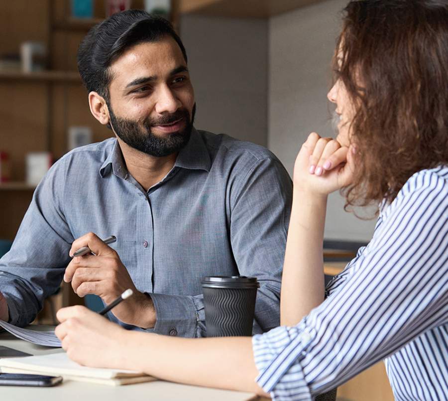 A clinical supervisor engages in a one-on-one conversation with a supervisee during a training session.